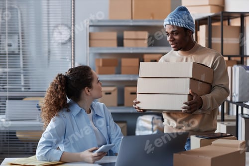 Preview: Young black man bringing stack of packed boxes with orders of clients