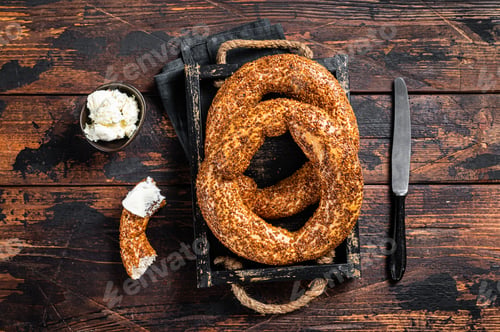 Preview: Stack of fresh baked Turkish simit bagel with kaymak. Wooden background. Top view