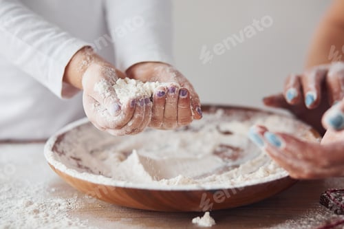 Preview: Close up view of woman with her granddaughter preparing food with flour on kitchen