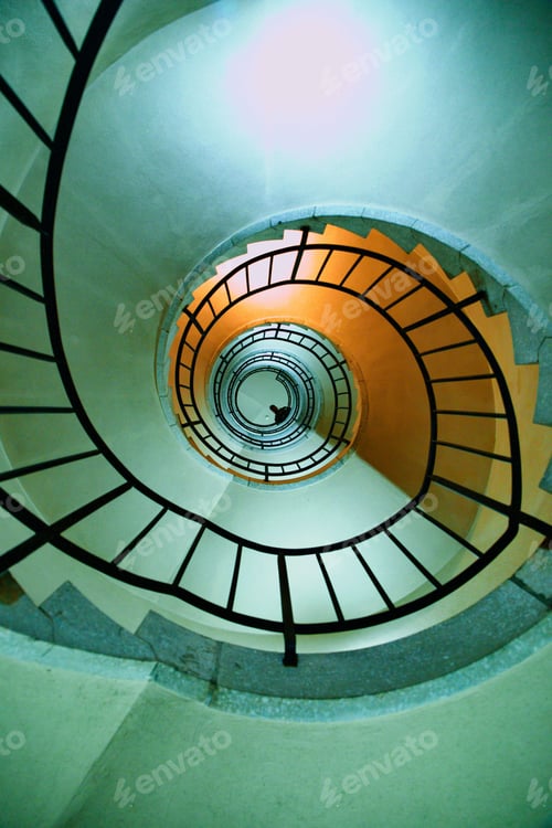 Preview: Vertical low angle shot of spiral stairs with a male looking down