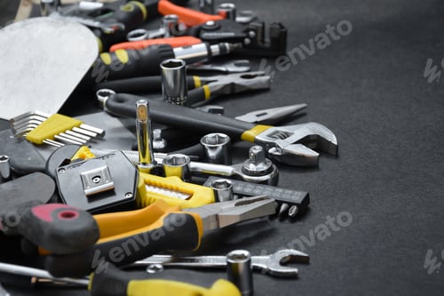 Preview: Handyman tool kit on black wooden table. Many wrenches and screwdrivers