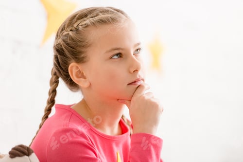 Preview: Adorable thoughtful child with braids touching chin