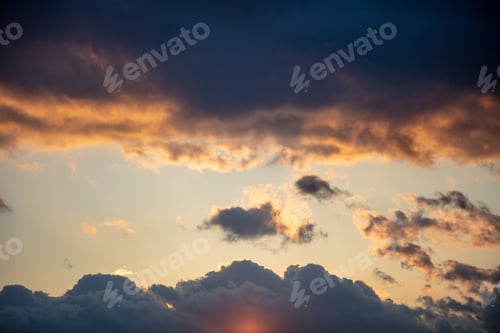 Preview: Sunbeams through dark clouds on blue sky background.