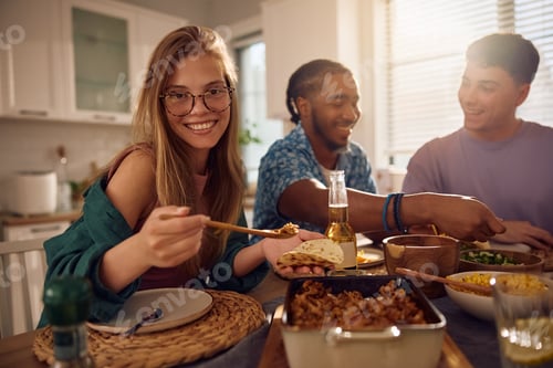 Preview: Happy woman enjoying in Mexican food during lunch party with friends and looking at camera.