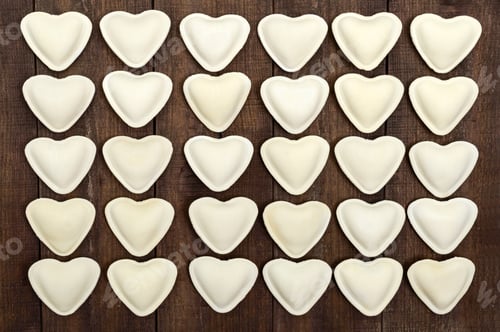 Preview: Uncooked dough in the shape of a heart (dumplings, ravioli, pelmeni), laid out in rows