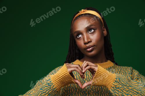 Preview: Young black woman showing heart gesture at camera