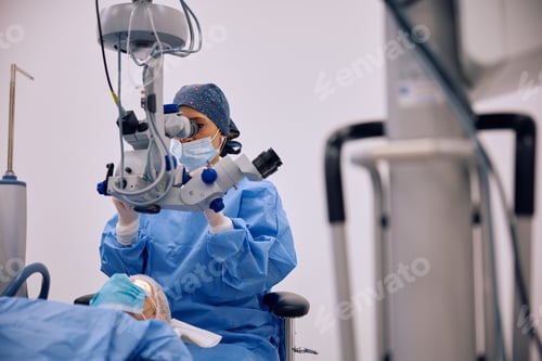 Preview: Medical expert performing an eye surgery under the microscope at ophthalmology clinic.