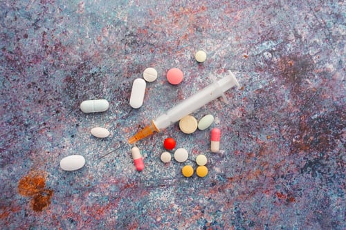 Preview: syringe and pills on dark background, close up