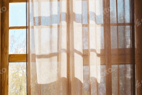 Preview: Sunlight through sheer curtain on wooden window frames casting soft geometric shadows indoors