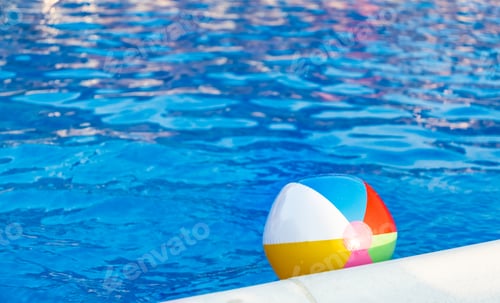 Preview: The ball floats on the water surface in the pool under the summer sun
