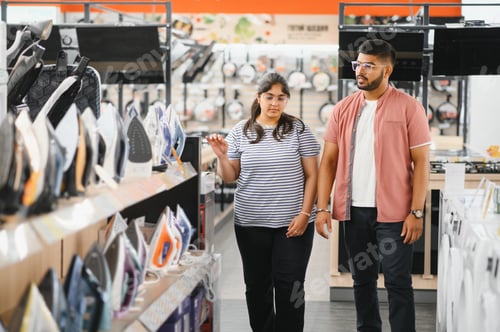 Preview: Indian Couple standing in an electronics store choosing an electric iron for Ironing things