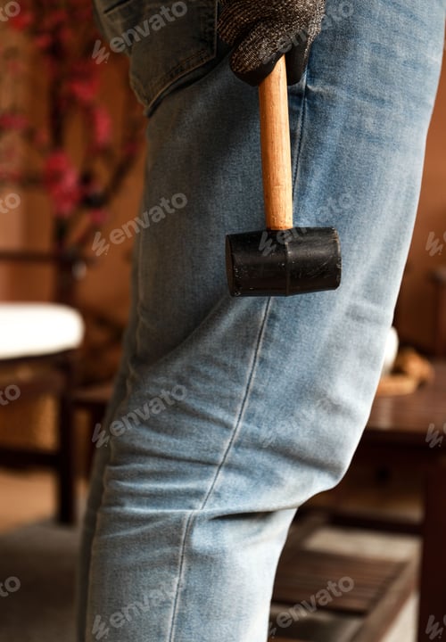 Preview: Vertical shot of a hammer in the hand of a worker