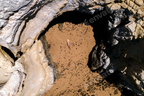 Preview: anonymous Tanned young woman relaxing on rocky coast in summer