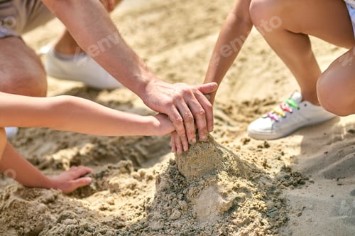 Preview: Close up picture of hands making castles from sand