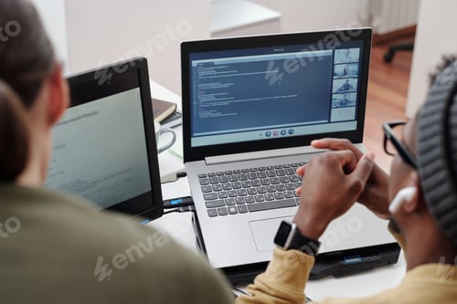 Preview: Hands of young black man over keypad of laptop with video chat on screen