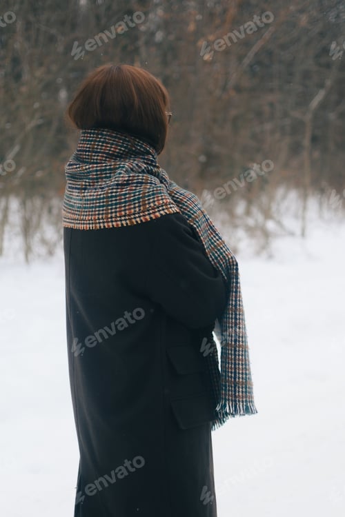 Preview: Woman in a plaid scarf standing in the snow