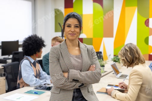 Preview: Confident businesswoman leading diverse team in modern office