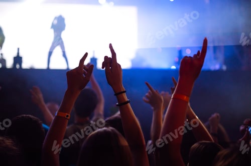 Preview: Сrowd with raised hands at music festival. Fans enjoying rock concert with light show clapping hands