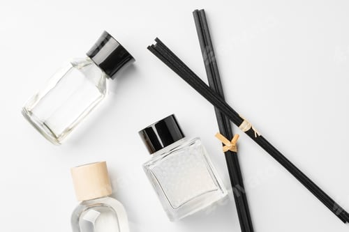 Preview: Elegant arrangement of essential oil diffusers with reeds and glass bottles on a minimalist surface