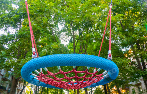 Preview: Round swing seat made of mesh in playground. Empty blue rope web nest for swinging