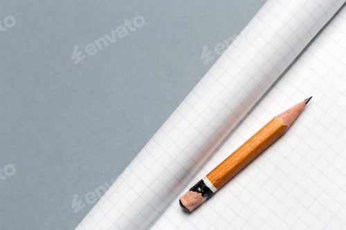 Preview: Short worn pencil with notepad on gray desk