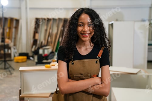 Preview: Young woman working as carpenter in a small carpentry workshop.