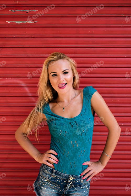 Preview: a young woman in a sexy position showing her tongue with a strong red background