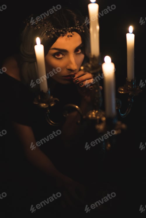 Preview: attractive woman with vintage candelabrum on dark background