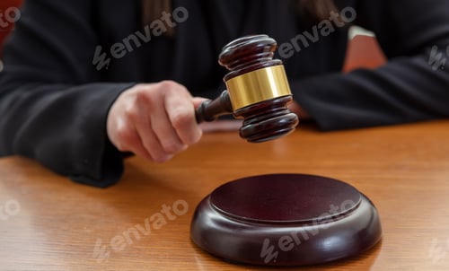 Preview: Judge female hand hold a gavel on law court bench, close up. Justice and punishment concept