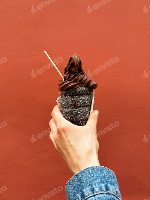 Preview: Popular European Czech Dessert Trdelnik Trdlo With Chocolate Ice Cream in Hand on Orange Background