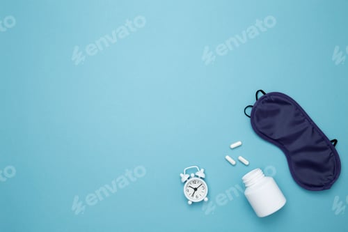 Preview: Sleep essentials eye mask, pills, clock. Concept of relaxation and rest, insomnia treatment