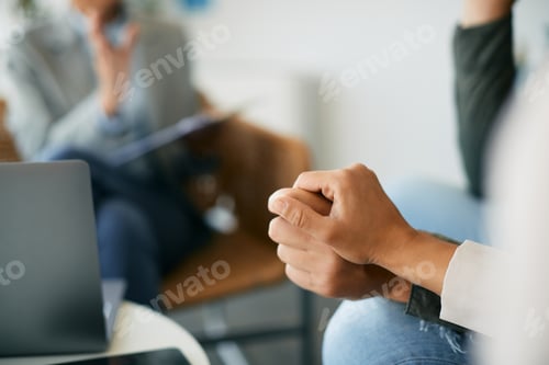 Preview: Close-up of couple holding hands during a meeting with insurance agent.