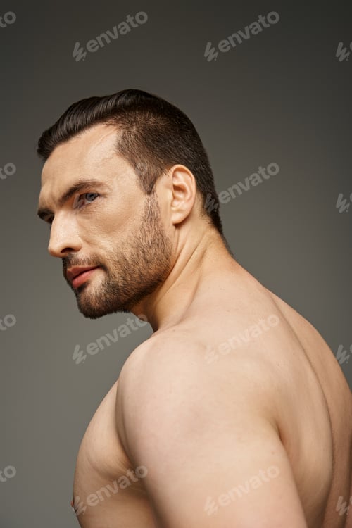 Preview: portrait of shirtless and handsome man with bristle looking away while posing on grey backdrop