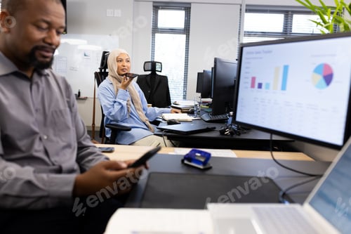 Visualização: Empresário afro-americano feliz com smartphone sentado na mesa no escritório