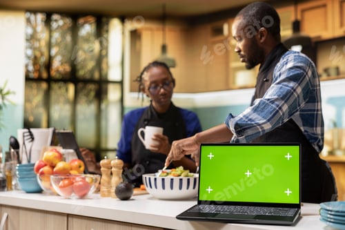 Preview: Isolated mockup laptop next to couple doing meal prep in the kitchen