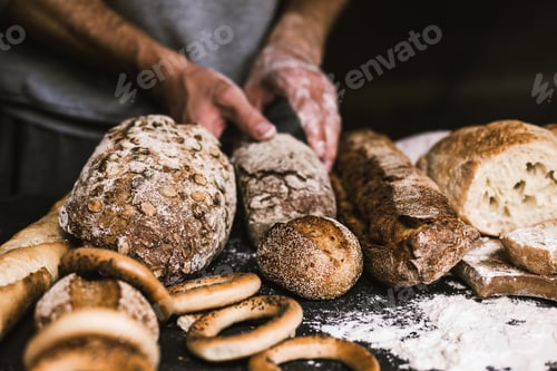 Preview: Baker man holding a rustic organic loaf of bread in his hands