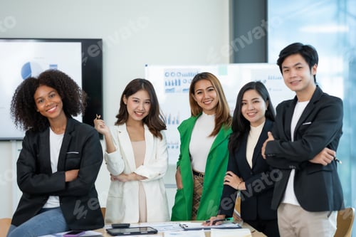 Preview: Young businessman and a beautiful Asian businesswoman stand with her arms crossed and pose for a bea