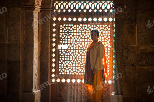 Preview: Indian woman in front of stone carving window