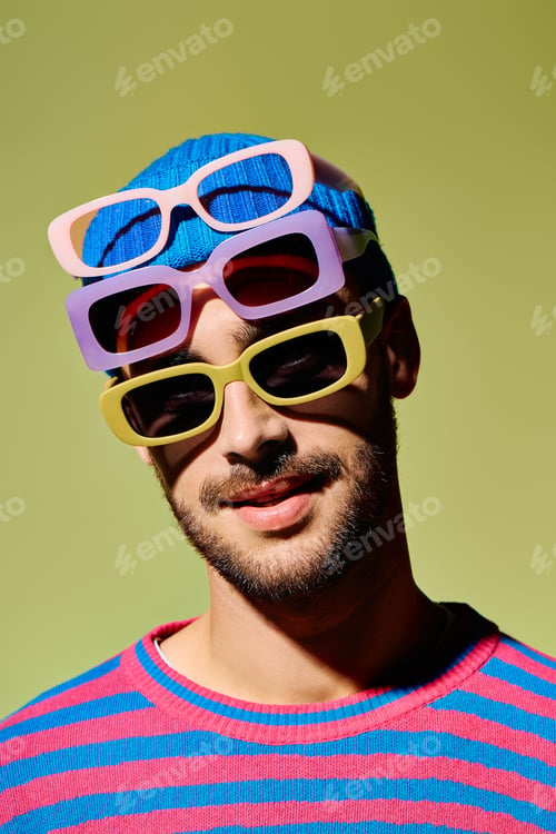Preview: Young man displays vibrant fashion sense with stylish sunglasses in studio setting