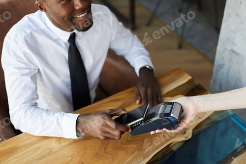 Preview: Businessman paying for lunch with smartphone