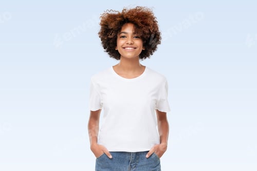 Preview: Front view of african american girl standing with hands in pockets, wearing blank t-shirt