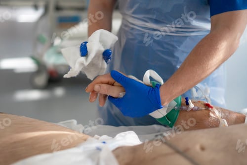 Preview: Nurse cleaning patient's hand with gauze and alcohol in hospital room
