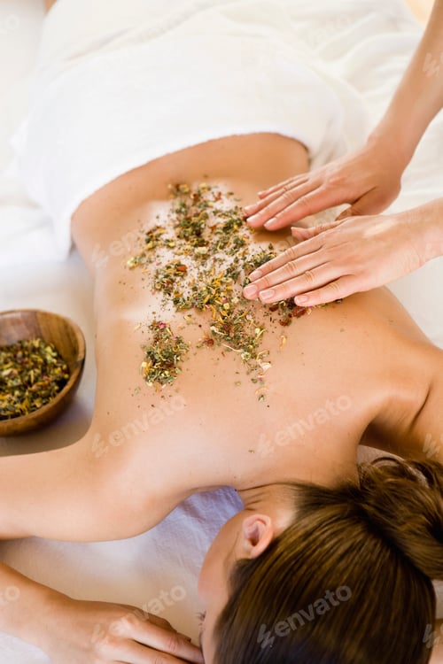Preview: Hands massaging woman's back with herbs