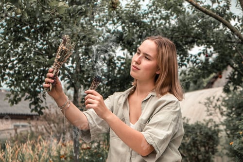 Preview: Woman Inhaling Incense Smoke During Meditation Ground level of relaxed female meditating and breathi