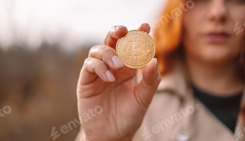 Preview: Golden bitcoin in a business woman hand outdoors. Cryptocurrency concept