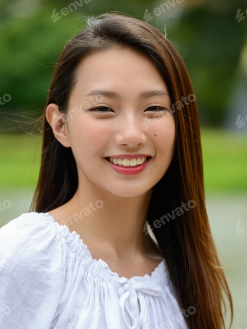 Preview: Happy young beautiful Asian teenage girl at the park