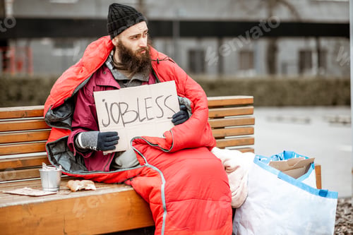 Preview: Homeless beggar on the bench near the business center