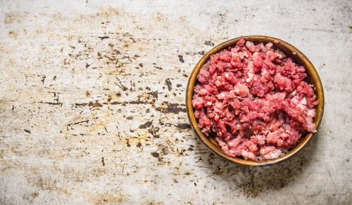 Preview: Fresh raw minced meat in a wooden bowl.
