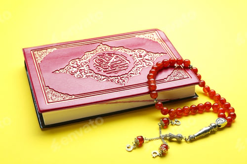 Preview: Muslim prayer beads and Quran on yellow background