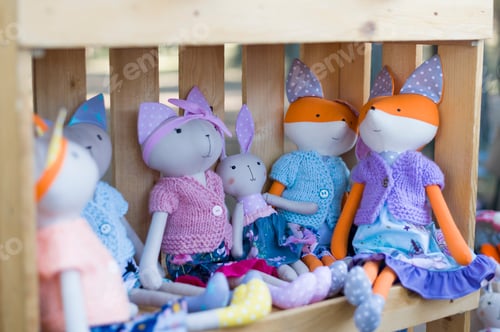 Preview: Children toys sitting in a wooden crate. Fox toys dressed in knitted jackets